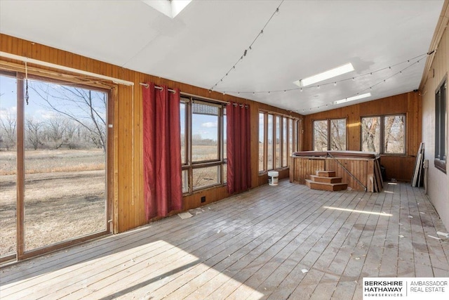 unfurnished sunroom featuring lofted ceiling with skylight