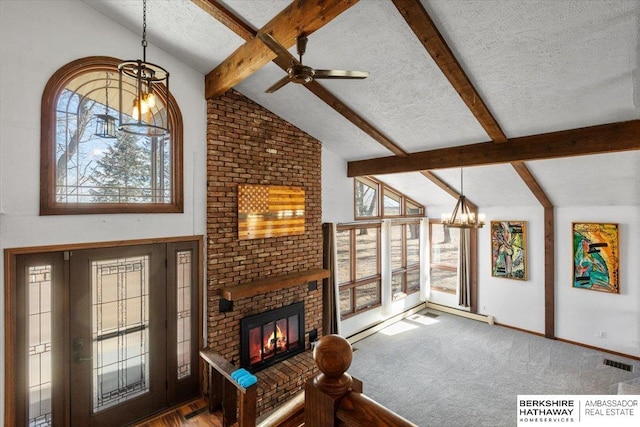 carpeted living room with a textured ceiling, a fireplace, visible vents, beamed ceiling, and an inviting chandelier