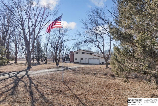 exterior space with a garage and dirt driveway