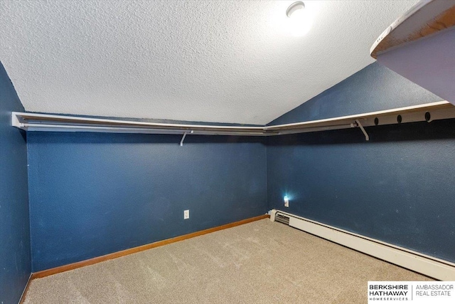 walk in closet featuring carpet floors, vaulted ceiling, and baseboard heating