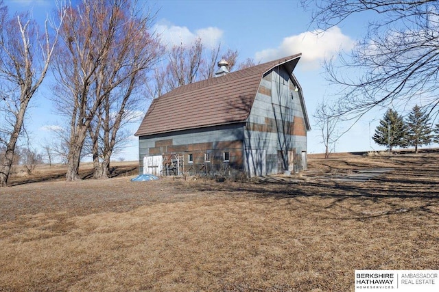 exterior space with a barn, an outbuilding, a lawn, and a gambrel roof