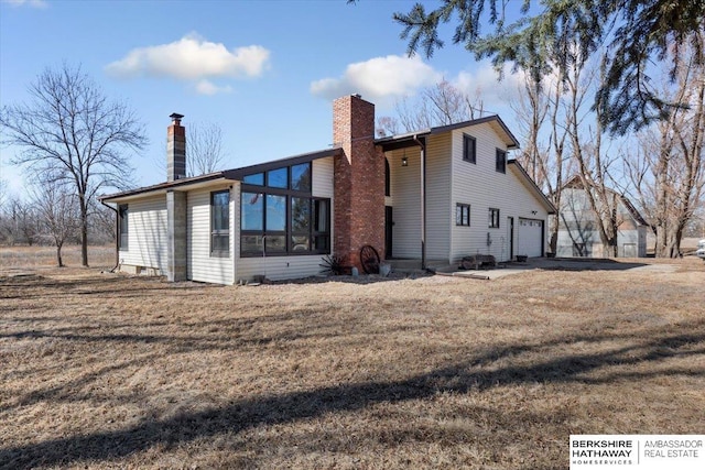 back of property with a sunroom, a chimney, and a lawn