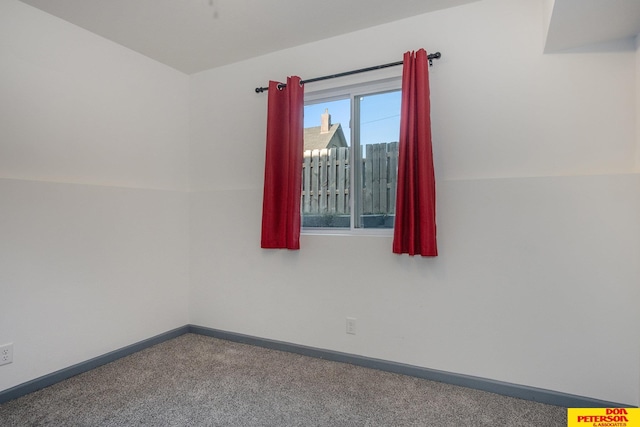 unfurnished room with carpet floors, a city view, and baseboards