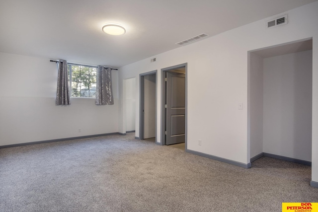 unfurnished bedroom with carpet, visible vents, and baseboards