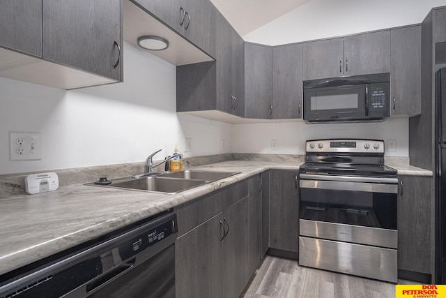 kitchen with light wood finished floors, a sink, stainless steel range with electric stovetop, black microwave, and dishwashing machine