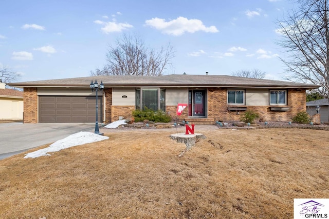 single story home with a garage, concrete driveway, brick siding, and a front lawn