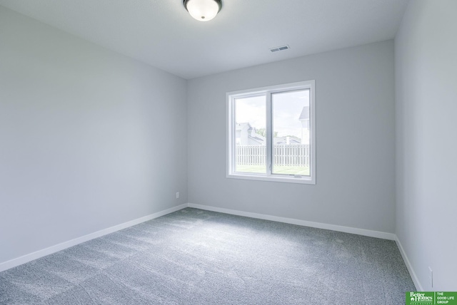 spare room with carpet floors, visible vents, and baseboards