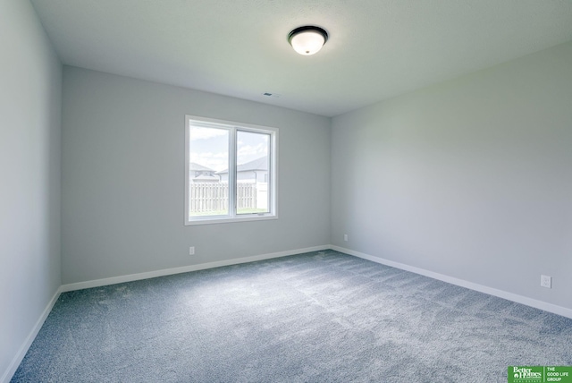 spare room featuring carpet floors and baseboards