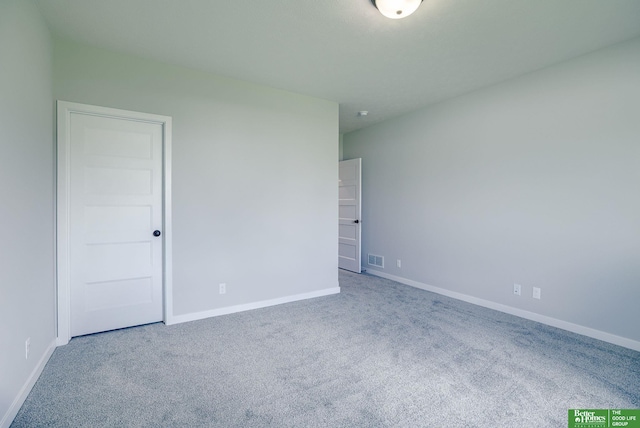 carpeted spare room featuring visible vents and baseboards