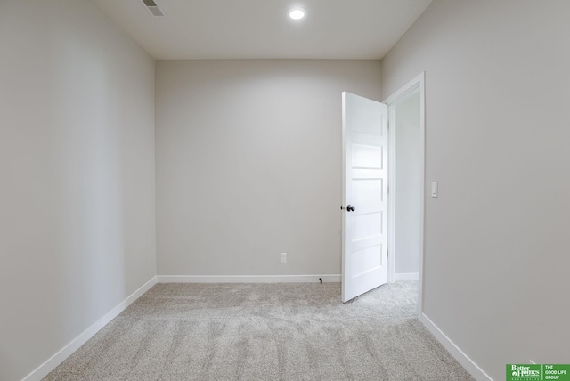 empty room with carpet floors, visible vents, and baseboards