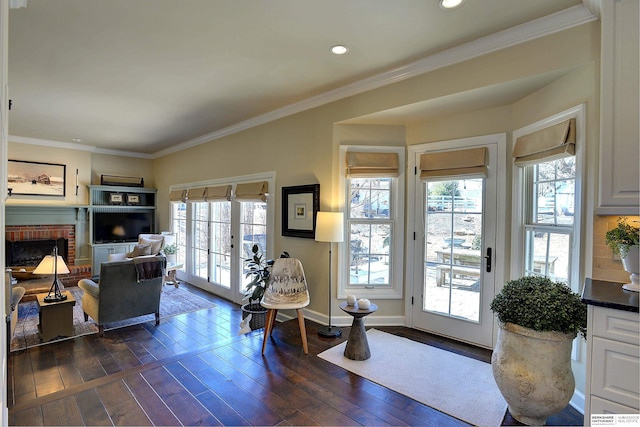 living area with baseboards, french doors, a brick fireplace, dark wood-style floors, and crown molding