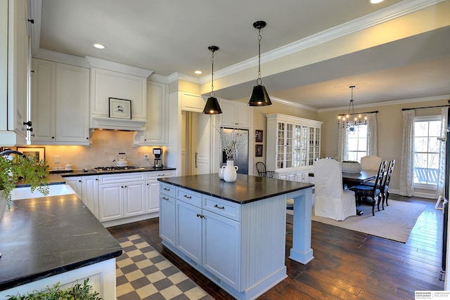 kitchen with ornamental molding, white cabinetry, dark wood finished floors, and fridge