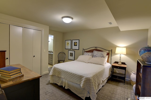 bedroom featuring carpet floors, connected bathroom, visible vents, and a closet