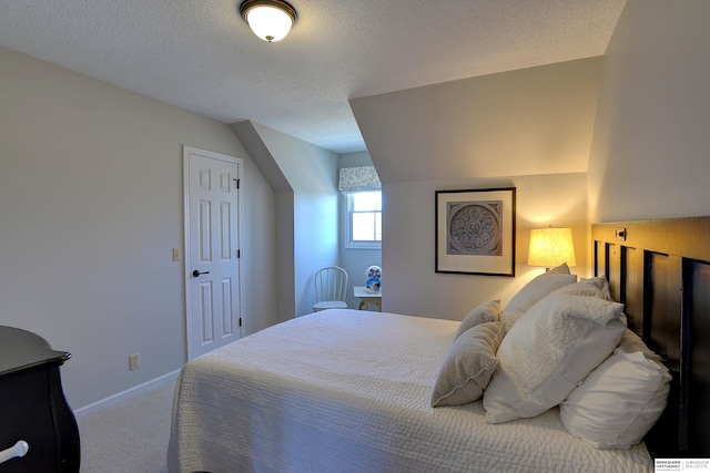 carpeted bedroom featuring lofted ceiling, a textured ceiling, and baseboards