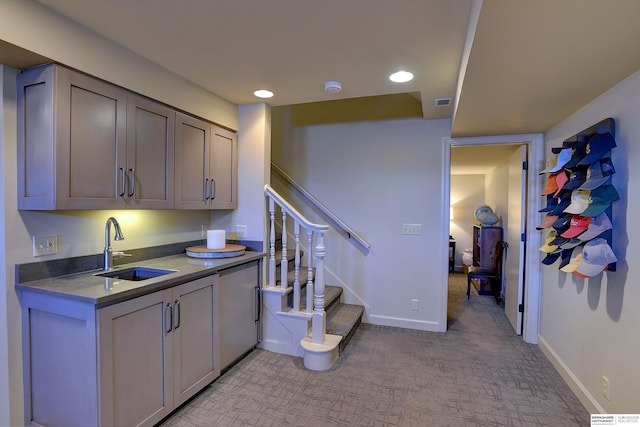 kitchen featuring baseboards, a sink, and gray cabinetry