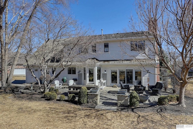 rear view of property with an outdoor fire pit and a patio area