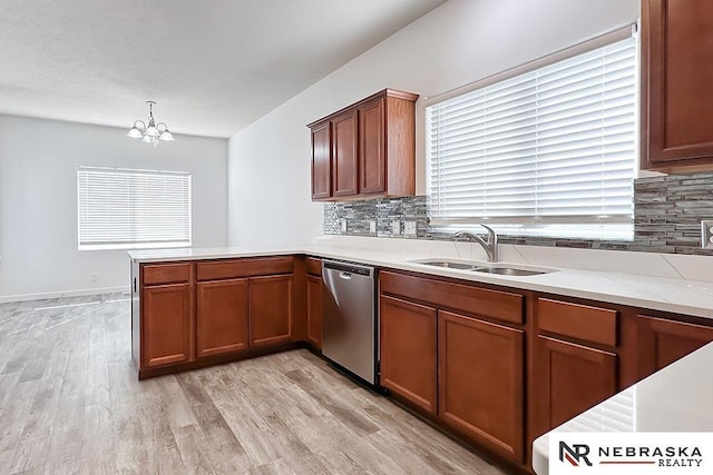 kitchen featuring decorative backsplash, dishwasher, a peninsula, and a sink