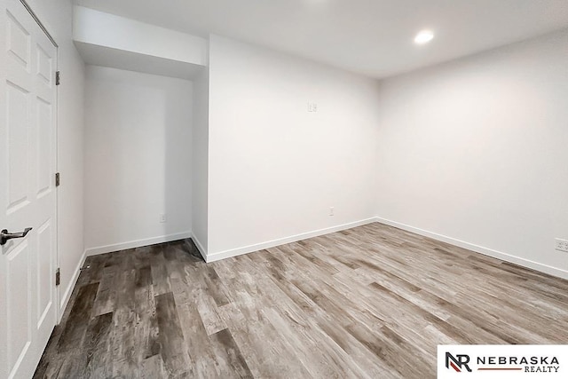 spare room with recessed lighting, baseboards, and wood finished floors