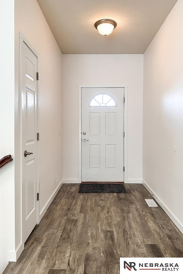 entryway featuring dark wood-style floors, baseboards, and a textured ceiling