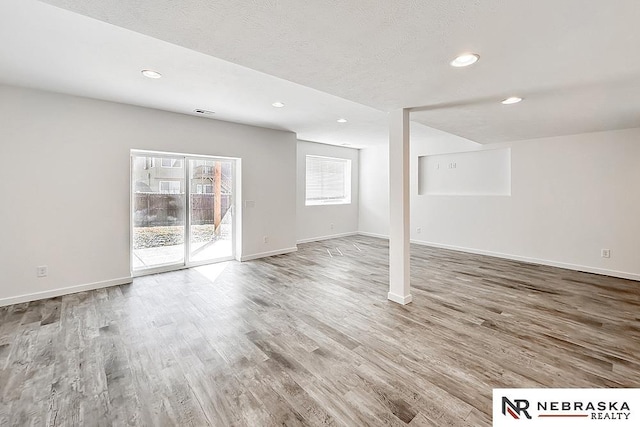 below grade area featuring baseboards, wood finished floors, and recessed lighting