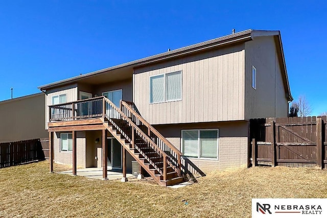 back of property featuring a gate, stairs, fence, a patio area, and brick siding