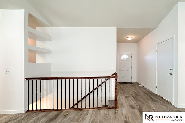 entryway with baseboards and wood finished floors