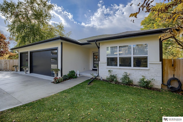 single story home featuring an attached garage, fence, concrete driveway, stucco siding, and a front yard