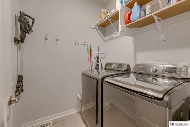 washroom with laundry area, washing machine and dryer, visible vents, and baseboards