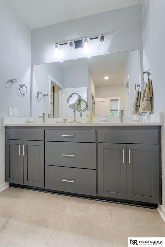 full bath featuring baseboards and double vanity