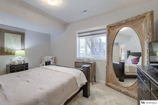 bedroom featuring light carpet, visible vents, and baseboards