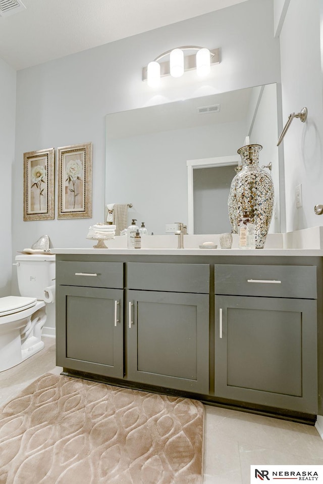 half bath featuring toilet, tile patterned flooring, vanity, and visible vents