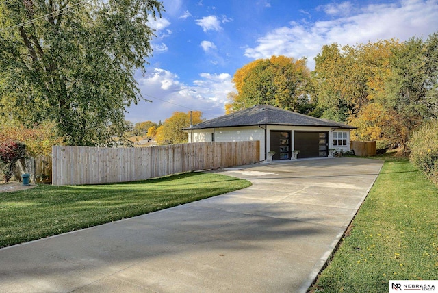 ranch-style home with a garage, concrete driveway, a front yard, and fence