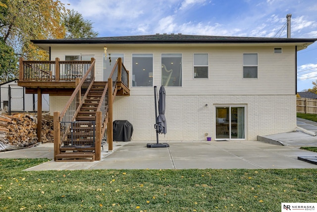 back of property with brick siding, fence, stairway, and a patio