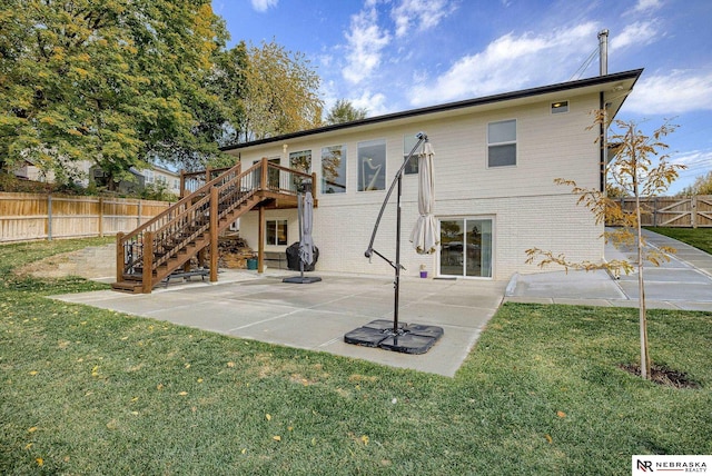 rear view of house with a patio, a fenced backyard, stairs, a yard, and brick siding