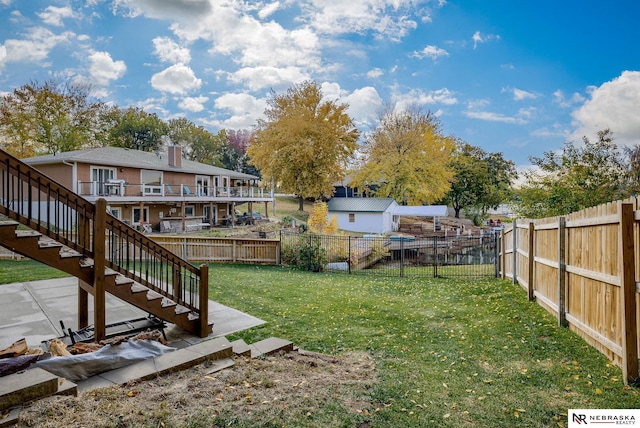 view of yard with a fenced backyard and stairway