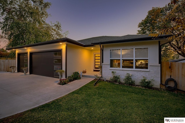 view of front of home featuring driveway, a garage, fence, and a yard