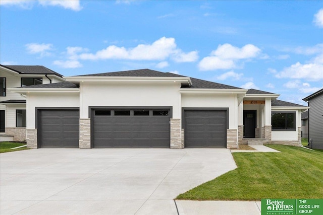 prairie-style house featuring a garage, driveway, stone siding, stucco siding, and a front yard