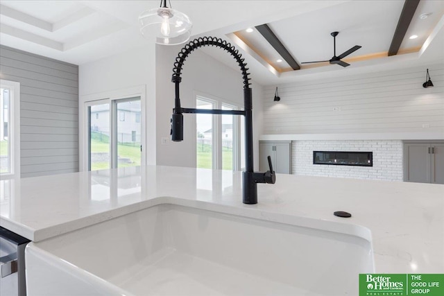 interior details featuring recessed lighting, wooden walls, a ceiling fan, a brick fireplace, and beamed ceiling