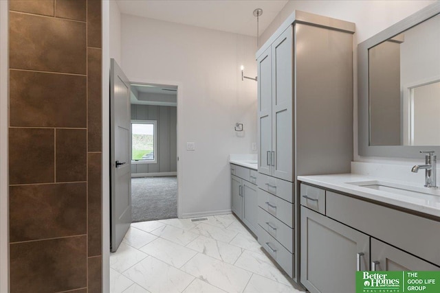 full bath with marble finish floor, vanity, and baseboards