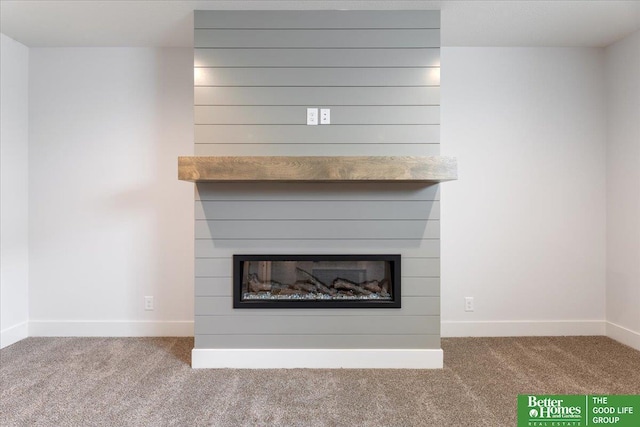 interior details with a glass covered fireplace, carpet flooring, and baseboards