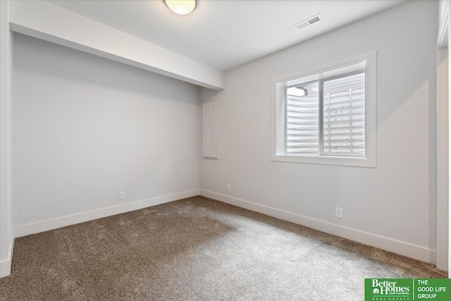 empty room featuring carpet floors, visible vents, and baseboards