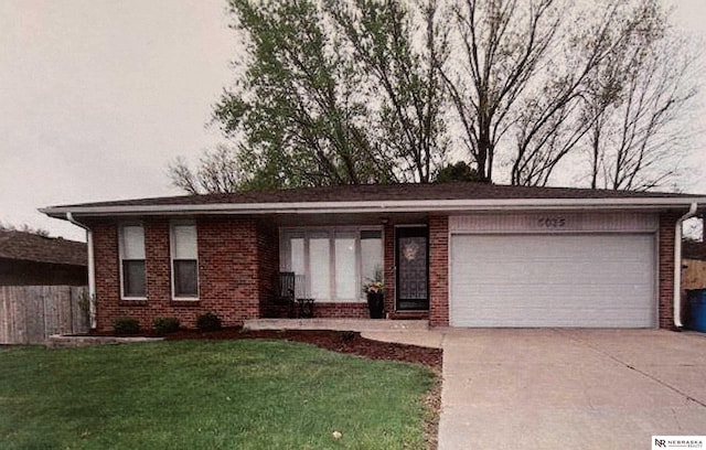 view of front of home featuring brick siding, a garage, concrete driveway, and a front yard