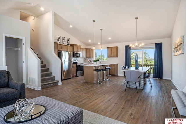 living room featuring high vaulted ceiling, dark wood-type flooring, visible vents, stairway, and an inviting chandelier