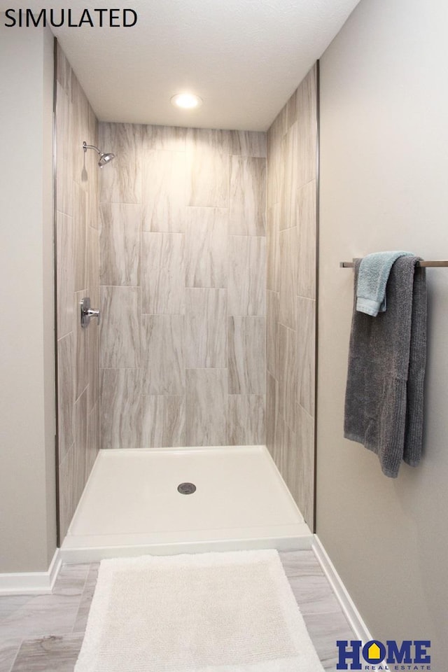 bathroom featuring baseboards and a tile shower