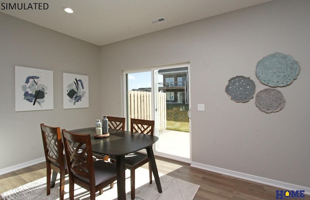 dining room featuring visible vents, baseboards, wood finished floors, and recessed lighting