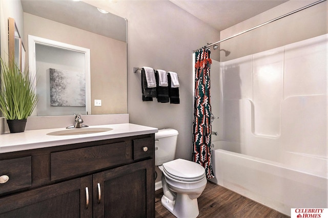 bathroom with toilet, shower / tub combo with curtain, wood finished floors, and vanity