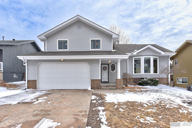 split level home featuring an attached garage, concrete driveway, brick siding, and a shingled roof