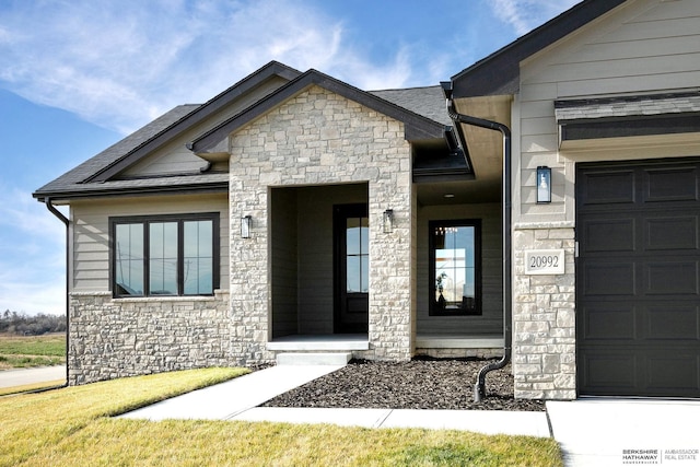 view of exterior entry with a garage and stone siding