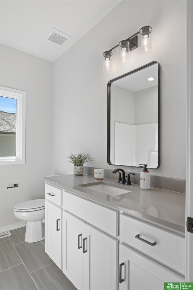 bathroom featuring toilet, visible vents, and vanity