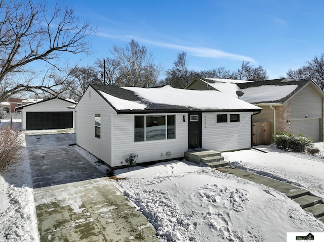 view of front of house with a detached garage and an outbuilding